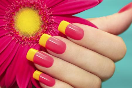 A pink manicure with yellow tips. 